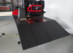 SL-6090 lawn mower zero turn lift table with 4 ramps across the full width of the table. Shown with gravely zero turn mower.